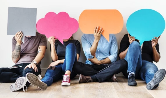 quatro pessoas sentadas segurando um balão de texto, simbolizando o blogpost sobre como responder as mensagens de Facebook corretamente.