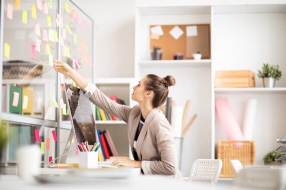 Mulher mexendo em post its. A imagem representa o blogpost Sua marca tem motivo para existir