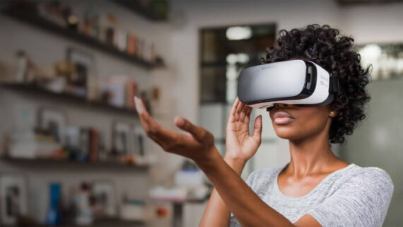 mulher com óculos de realidade virtual, com a mão estendida