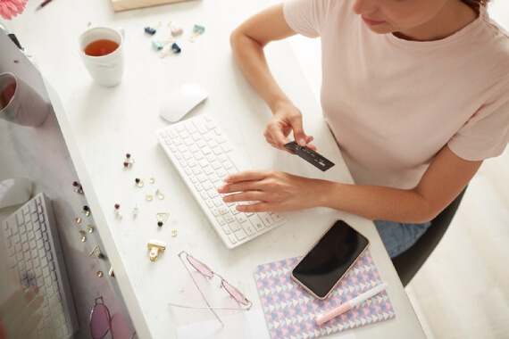 Mulher com um cartão de crédito na mão. A imagem simboliza o blogpost sobre a melhor forma de pagamento para seu e-commerce