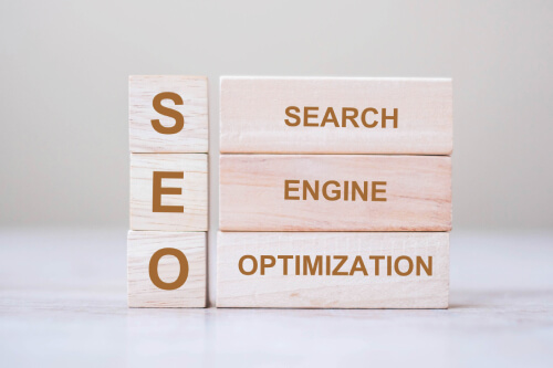 blocos de madeira empilhados formando a sigla SEO e o significado search engine optimization
