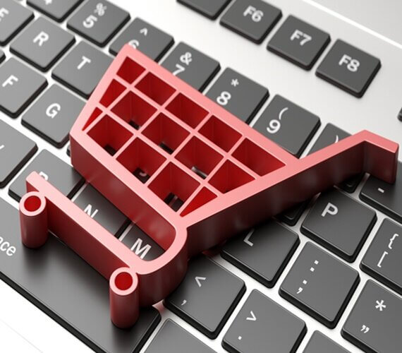 Imagem ilustrativa de um carrinho sobre um teclado de computador, fazendo alusão ao e-commerce.